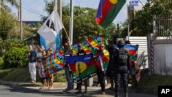 People demonstrate as French President Emmanuel Macron's motorcade goes past in Noumea, New Caledonia, May 23, 2024.