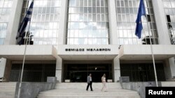 FILE - People walk outside Greece's Supreme Court in Athens, Sept. 17, 2012. The court assembly voted nine to one to disqualify Ilias Kasidiaris and his party, called The Greeks, from the May 21 polls.