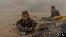 FILE - Afghan children work in a brick factory on the outskirts of Kabul, Afghanistan, Aug. 20, 2022. 