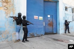National Police stand guard outside the empty National Penitentiary after a small fire inside in downtown Port-au-Prince, Haiti, March 14, 2024.