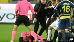 Referee Halil Umut Meler lies on the ground after being punched by MKE Ankaragucu president Faruk Koca, center, at the end of the Turkish Super Lig soccer match between MKE Ankaragucu and Caykur Rizespor in Ankara, Dec. 11, 2023. 
