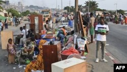 Des habitants expulsés se rassemblent dans la rue avec leurs biens dans le quartier Boribana d'Attecoube à Abidjan, après la démolition de leurs maisons le 26 février 2024. (Photo d'Issouf SANOGO / AFP)
