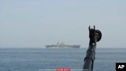 A machine gun's muzzle of a Revolutionary Guard speedboat is seen as the boat moves near USS Bataan at the Strait of Hormuz