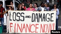 សកម្មជន​ខាង​បរិស្ថាន​កាន់​បដា​ដែល​សរសេរ​ថា «ផ្តល់​ថវិកា​ពេល​នេះ​សម្រាប់​ការ​​​​ខូច​ខាត​និង​បាត់បង់​ (loss and damage)‍»​អំឡុង​ការ​តវ៉ា​មួយ​នៅ​ទី​ក្រុង​ប៉ារីស​ប្រទេស​បារាំង​កាលពី​ថ្ងៃ​ទី​២៣ ខែ​តុលា ឆ្នាំ​២០២៣។