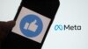 Dans cette photo d'illustration de fichier prise le 28 octobre 2021, montre une personne utilisant Facebook sur un smartphone devant un écran d'ordinateur affichant le logo META à Los Angeles. – Le propriétaire de Facebook, Meta,