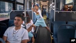 Migrant Darwin Salinas, 24, left, travels with wife Kimberly Carchipulla, 23, second left, partly seen, and sons Damien, 6, and Derek, 1, June 16, 2024, near Newark, NJ. 