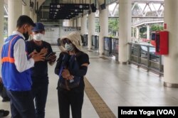 Sebagian masyarakat Jakarta kembali menggunakan masker guna mencegah penyakit pernafasan di Halte Bus Dukuh Atas, Senin (21/8). (Foto: VOA/Indra Yoga)