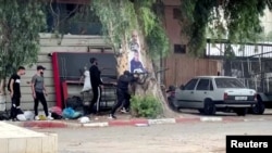 A Palestinian gunman fires a weapon during clashes with Israeli troops at a raid in Jenin, in the Israeli-occupied West Bank June 19, 2023, in this still picture taken from a video. (Reuters/Raneen Sawafta)