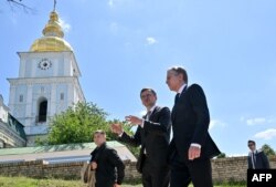 U.S. Secretary of State Antony Blinken, right, listens to his Ukrainian counterpart Dmytro Kuleba, center, as they walk past St. Michael's Golden-Domed Monastery in Kyiv, Ukraine, May 15, 2024.