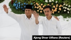 FILE - Presiden terpilih Prabowo Subianto dan wakil presiden terpilih Gibran Rakabuming Raka melambaikan tangan mereka setelah KPU resmi mengumumkan mereka sebagai pemenang pemilu presiden di markas KPU di Jakarta, 24 April 2024. (Ajeng Dinar Ulfiana/REUTERS)