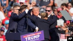 FILE - Republican presidential candidate former President Donald Trump is led off the stage shortly after an assassination attempt against him, at a campaign rally in Butler, Pennsylvania, July 13, 2024.