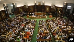 FILE- Newly elected lawmakers from India's ruling alliance led by the Hindu nationalist Bharatiya Janata Party raise their hands in support of Narendra Modi being elected their leader in New Delhi, May 25, 2019. 