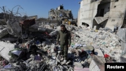 FILE - Naser al-Wakaa stands on the rubble of his home, ruined in the Feb. 6 earthquakes, in the rebel-held town of Jandaris, Syria, Feb. 9, 2023.