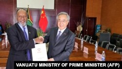 瓦努阿图总理办公室2024年7月2日发布图片显示，瓦努阿图总理萨尔瓦伊（左）与中国全国政协副主席胡春华在新总统府的正式移交给瓦努阿图政府的仪式上握手。