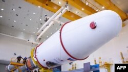 This handout photograph taken and released by the Russian Space Agency Roscosmos on August 7, 2023, shows technicians finishing to assemble a Soyuz 2.1b rocket carrying the Luna-25 lander ahead of its launch scheduled for August 11, 2023.