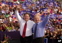 FILE - Capres Partai Demokrat Wakil Presiden Al Gore (kiri), dan pasangannya, Cawapres Senator Joe Lieberman, dari Connecticut, melambaikan tangan ke arah para pendukungnya pada kampanye di Jackson, Tennessee., 25 Oktober 2000.