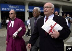 FILE - Actor Ed Asner, right, along with the Rev. Don Brown, left, and the Rev. James Lawson, center, walk to the Capitol, in Sacramento, Calif. carrying petitions calling for a "time out" of the death penalty, May 1, 2002.