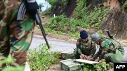 FILE - This photo taken on December 13, 2023, shows members of ethnic minority armed group Ta'ang National Liberation Army preparing their weapons amid clashes with Myanmar's military in Namhsan Township in Myanmar's northern Shan State.
