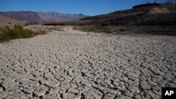 FILE - Cracked earth is visible in an area once under the water of Lake Mead at the Lake Mead National Recreation Area, on Jan. 27, 2023, near Boulder City, Nevada.