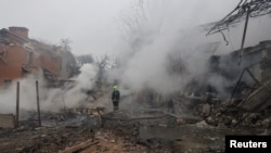 A rescuer stands in a residential area hit by a Russian missile strike in Odesa, Ukraine, March 15, 2024.