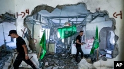 Warga Palestina memeriksa reruntuhan rumah milik keluarga Moataz Khawaja, seorang militan Hamas yang dihancurkan oleh pasukan Israel di desa Naalin, Tepi Barat, Selasa, 23 Mei 2023. (AP/Majdi Mohammed)