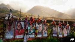 FILE — Photos are displayed at a memorial for victims of the August 2023 wildfire, above the Lahaina Bypass highway in Lahaina, Hawaii, Dec. 6, 2023. The last of the 100 known victims of the wildfire was identified Friday as Lydia Coloma, 70.