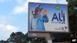 FILE - A defaced billboard of Gabon's ousted president, Ali Bongo, is seen on a street in Libreville, Gabon, Aug. 30, 2023. 