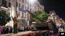 FILE - Members of the Wagner Group military company load their tank onto a truck on a street in Rostov-on-Don, Russia, June 24, 2023, prior to leaving an area at the headquarters of the Southern Military District. 
