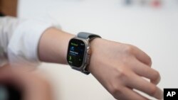 FILE - A person tries on an Apple Watch during an unveiling of new products on the Apple campus in Cupertino, California, Sept. 12, 2023.