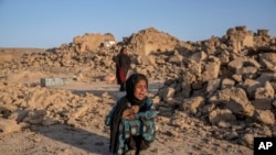 An Afghan girl cries in front of her house that was destroyed by the earthquake in Zindajan district in the Herat province of western Afghanistan, Oct. 11, 2023. 