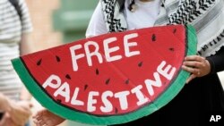 Seorang demonstran membawa atribut yang berisi seruan pembebasan Palestina dalam aksi protes menetang perangan Israel-Hamas di Gaza di kampus di Hattiesburg, Mississippi, pada 7 Mei 2024. (Foto: AP/Rogelio V. Solis)