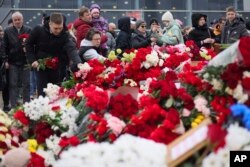 ประชาชนร่วมกันวางดอกไม้และของเล่นที่รั้วของ โครคัส ซิตี้ ฮอลล์ สถานที่จัดคอนเสิร์ตที่ชานกรุงมอสโก เมื่อวันที่ 24 มี.ค. 2567 เพื่อไว้อาลัยต่อเหยื่อเหตุยิงกราด