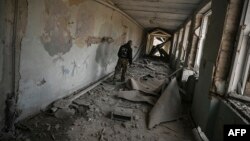 A local resident walks inside a destroyed school after a strike in Chasiv Yar, west of Bakhmut, eastern Ukraine, March 22, 2023. 