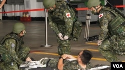 台湾空军花莲基地星期二(7月23日)操演战伤救护，在机棚内紧急开设伤员集结点，检伤分类后，快速后送(美国之音特约记者庄志伟拍摄)