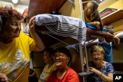 People travel in a train compartment on the way to Aralsk, Kazakhstan, June 30, 2023.