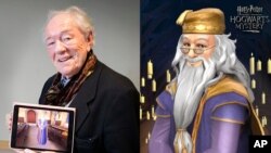 ไมเคิล แกมบอน ในบท ศาสตราจารย์อัลบัส ดัมเบิลดอร์ ยืนถือภาพตัวละครนี้ในวิดีโอเกม Harry Potter: Hogwarts Mystery (AP)