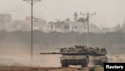 FILE - Israeli tanks re-enter Israel from Gaza, amid the ongoing conflict between Israel and the Palestinian Islamist group Hamas, near the Israel-Gaza border, in southern Israel, Jan. 11, 2024. 