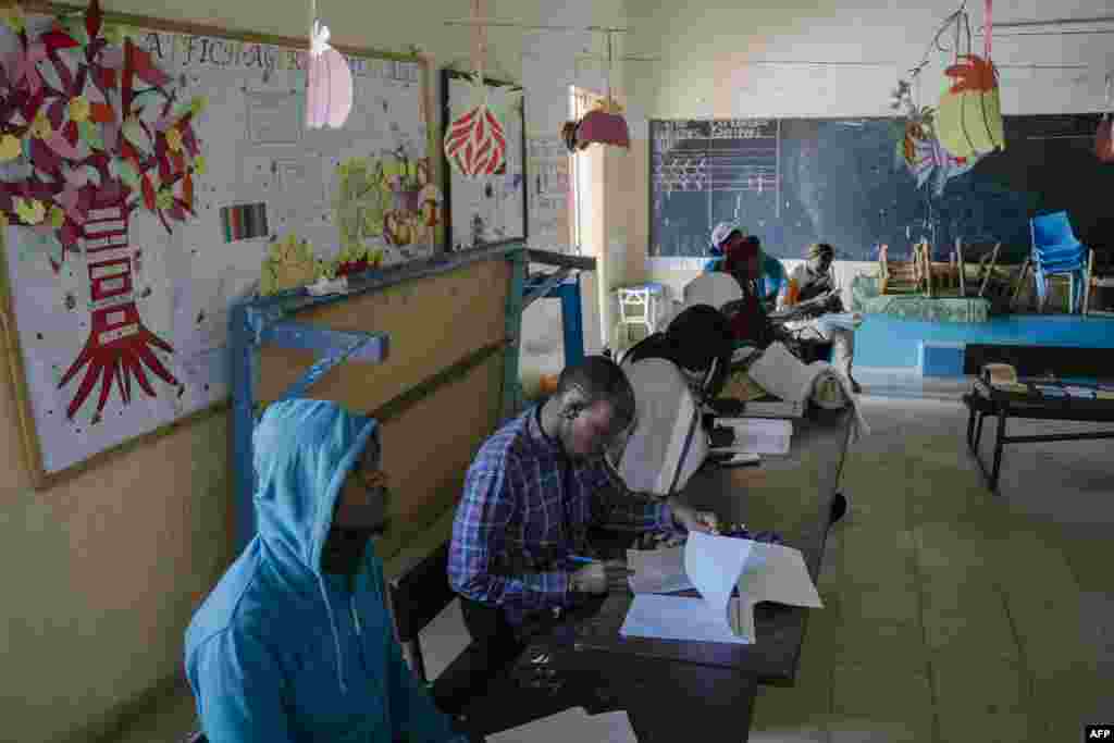 Commission Electorale Nationale Autonome (CENA) officials check the voters&#39; rolls at a polling station in a school in HLM Grand Medine on the outskirts of Dakar, Senegal, March 24, 2024.