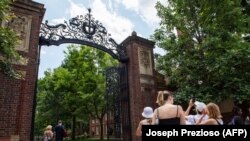 Sejumlah pelancong mengabadikan gerbang masuk ke Harvard Yard, di Cambridge, Massachusetts, 29 Juni 2023. (Foto: Joseph Prezioso/AFP)