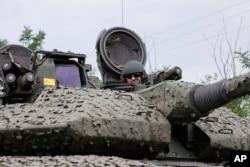 A Ukrainian soldier on a Swedish CV90 infantry fighting vehicle at his positions near Bakhmut, Donetsk region, Ukraine, June 25, 2023. (Roman Chop via AP)