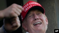 Former President Donald Trump laughs while looking over the 18th hole during the final round of the Bedminster Invitational LIV Golf tournament in Bedminster, NJ, Aug. 13, 2023. 