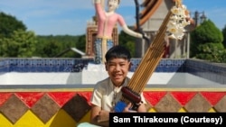 ທ້າວ ແດນນີ ພິລາວົງ, ອາຍຸ 11 ປີ, ເປັນຜູ້ເປົ່າແຄນປະຈໍາວົງດົນຕີພື້ນເມືອງຈະເຣີນສິນ.