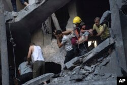 Warga Palestina mengevakuasi korban luka dari sebuah bangunan yang hancur akibat pemboman Israel di Khan Younis, Jalur Gaza, Kamis, 19 Oktober 2023. (Foto: AP)