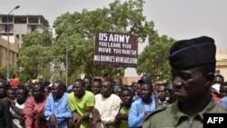 A man holds up a sign demanding that U.S. Army soldiers leave Niger without negotiation during a demonstration in Niamey, on April 13, 2024.