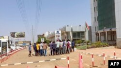 Locals gather after kicking out a group of looters who broke into a car showroom in southern Khartoum on May 7, 2023 as fighting continued in the Sudanese capital.
