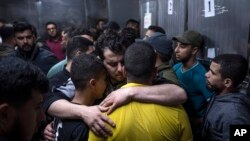 Palestinyen kap pote dey pou viktim atak Izrael yo rekonfote youn lot nan lopital Al-Shifa a nan Gaza Siti, 9 Me 2023. 