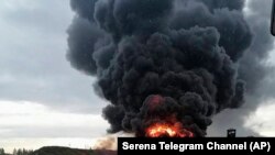 In this image released by Sirena telegram channel on Aug. 20, 2023, a Russian warplane is burning on the Soltsy air base in the Novgorod region in northwestern Russia. 