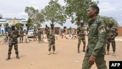 Nigerien soldiers stand guard as supporters of Niger's coup leaders gather for a demonstration in Niamey on Aug. 11, 2023, near a French airbase in Niger. 