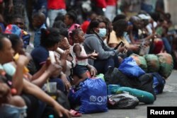 FILE - Migrants, mostly from Haiti, gather at the Giordano Bruno park as they wait for a permit that would allow them to continue their journey to the border between Mexico and the United States, in Mexico City, Mexico April 4, 2023.