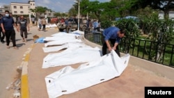 A man looks at a dead body, after a powerful storm and heavy rainfall hit Libya, in Derna, Libya Sept. 12, 2023. 